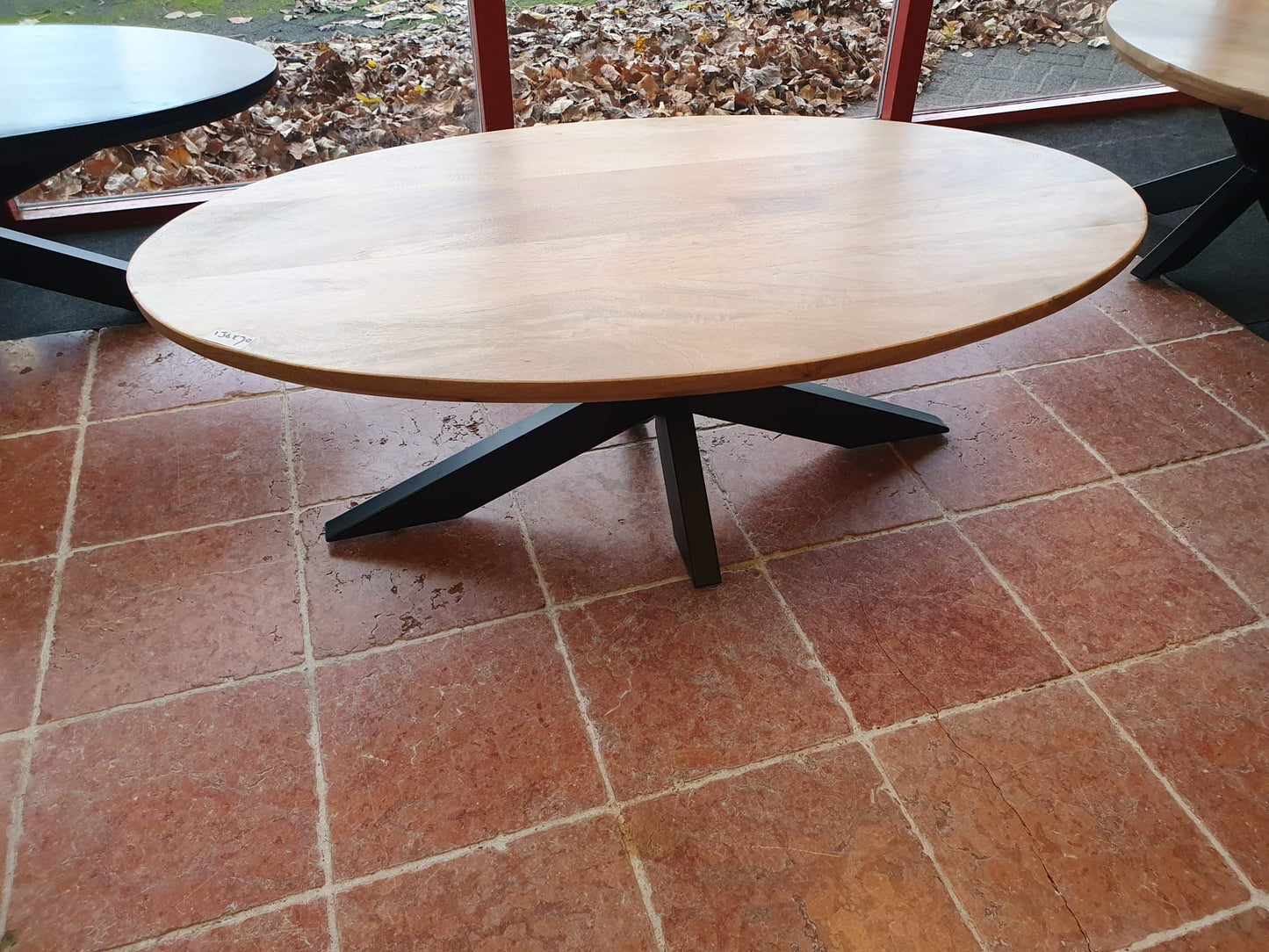 Gladde mangohouten naturelkleurige ovale salontafel met swiss edge 120x60cm incl. zwart metalen matrix/spinpoot
